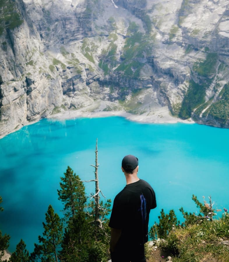 Turquoise alpine lake below steep cliffs