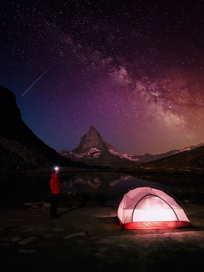Milky way over the Matterhorn and a lit tent at Riffelsee above Zermatt
