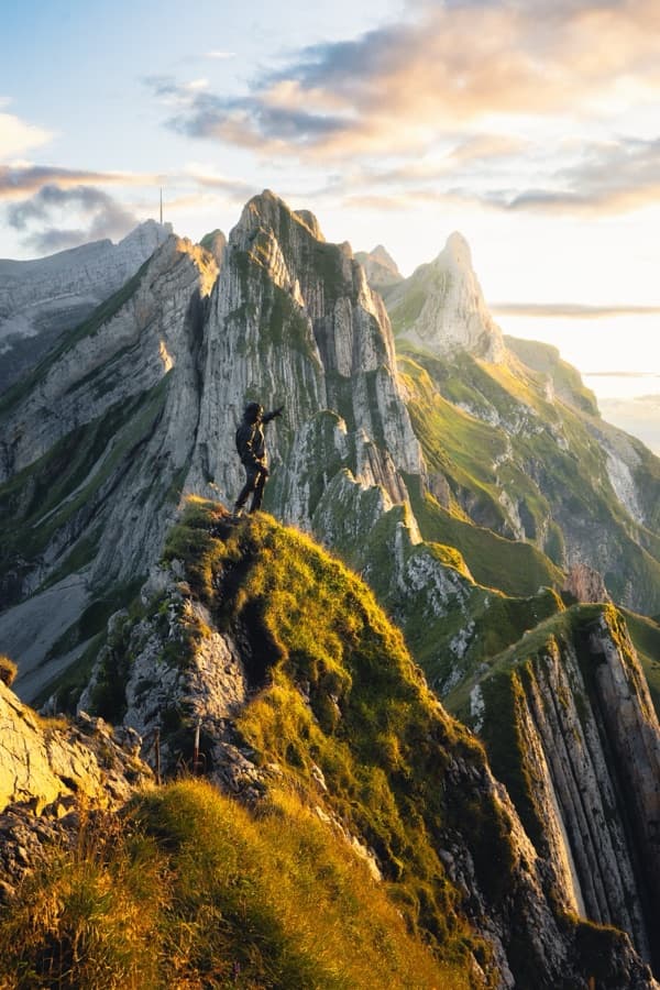 Hiker on the Schaefler ridge above the Alpstein at golden hour