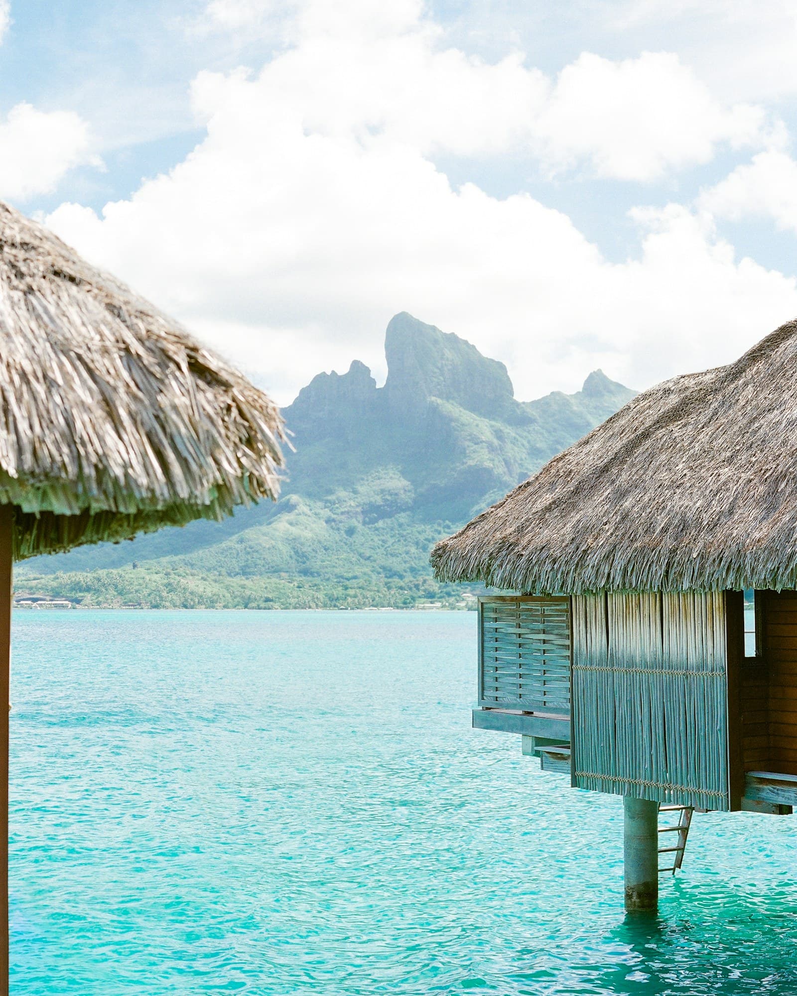 Thatched overwater bungalows framing Mount Otemanu across the turquoise Bora Bora lagoon